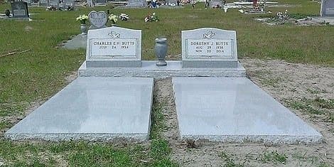 Two gray granite ledgers covering side-by-side graves, with headstones at the head.