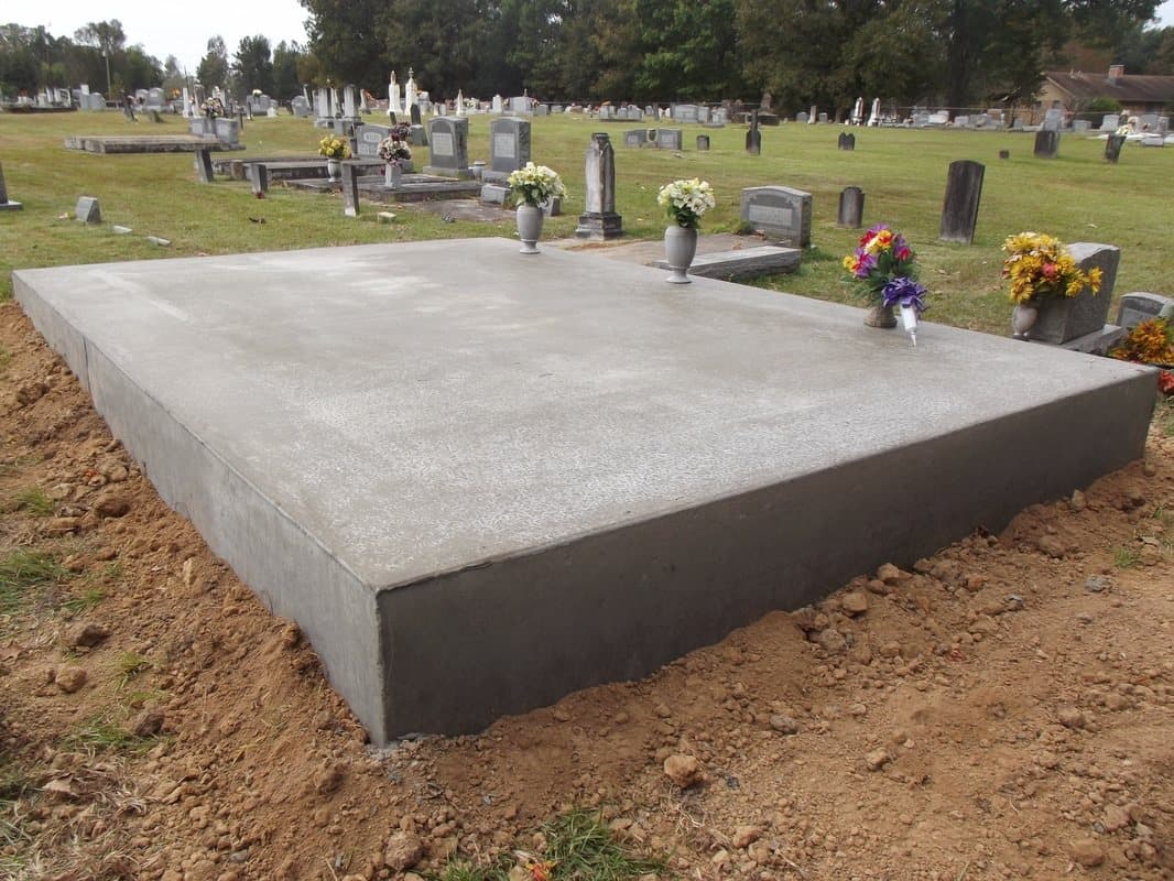 A large new concrete slab poured across a family plot.