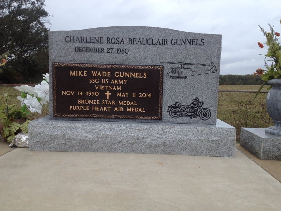 A veteran's bronze plaque mounted on a gray granite upright, listing service in Vietnam, a Bronze Star, a Purple Heart, and an Air Medal.