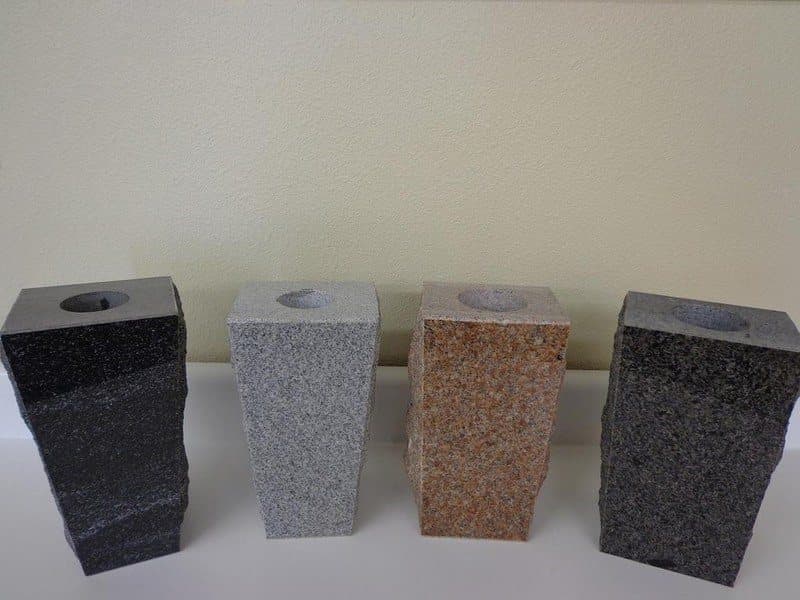 Four square granite vases in black, gray, red, and dark gray.