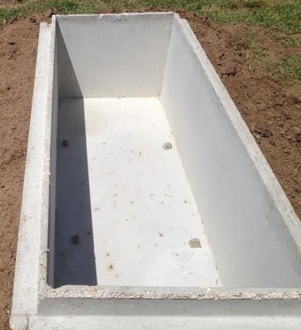 Looking down into an open concrete burial vault.