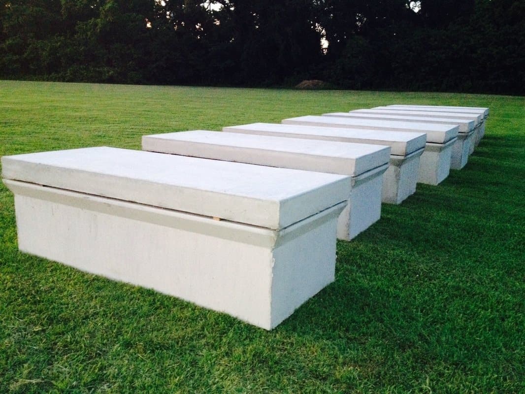 White concrete vaults lined up on the grass.