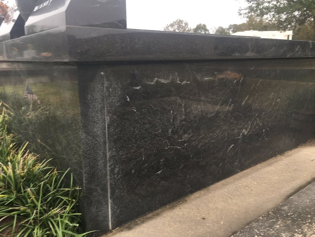 A black granite wrap covering the side of a vault.